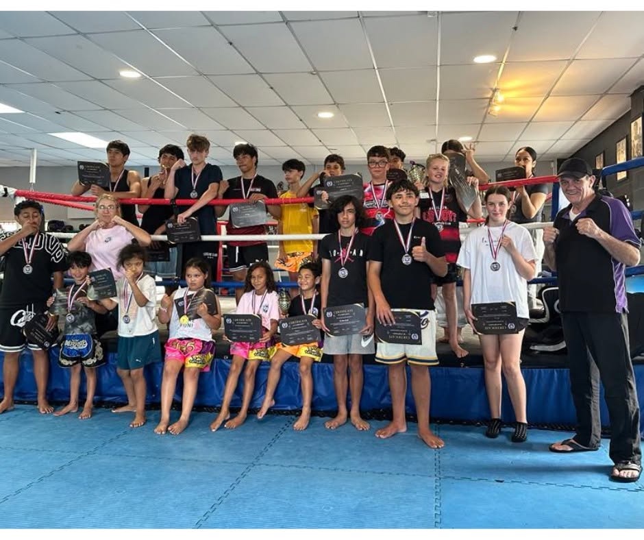 Stormforce junior and senior students with certificates and medals in the gym ring