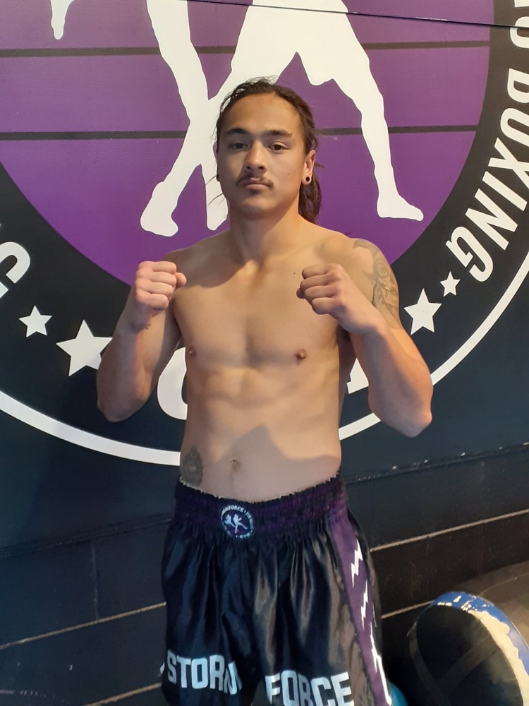 A Stormforce fighter standing ready in front of the gym logo